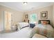 Comfortable bedroom showcasing twin beds, neutral decor, carpet and natural light at 3324 Thomas Rd, Raleigh, NC 27607