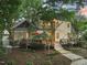 A beautifully landscaped home with a deck, stone patio, and lush greenery, perfect for outdoor entertaining and relaxation at 3324 Thomas Rd, Raleigh, NC 27607