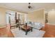 Living room features hardwood floors, gray sofa, two chairs and open concept to the kitchen at 3324 Thomas Rd, Raleigh, NC 27607