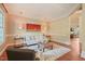 Bright living room with hardwood floors, white sofa, tufted ottoman, and statement art piece at 3324 Thomas Rd, Raleigh, NC 27607
