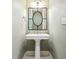 Stylish powder room featuring a pedestal sink and decorative mirror at 3324 Thomas Rd, Raleigh, NC 27607