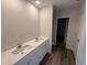 Bathroom featuring double sinks with quartz countertops, modern fixtures, and wood-look floors at 37 Chloe Ct, Selma, NC 27576