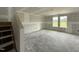 Unfinished living room featuring large windows, a staircase, and ready for personalization at 37 Chloe Ct, Selma, NC 27576
