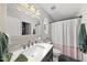 Bathroom with large vanity, oval window, and shower with curtain at 4413 Sugarbend Way, Raleigh, NC 27606