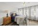 Bedroom with wood floors, ceiling fan, and large windows for natural light at 4413 Sugarbend Way, Raleigh, NC 27606