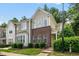 Townhome with brick facade and manicured lawn in a residential neighborhood surrounded by mature trees at 4413 Sugarbend Way, Raleigh, NC 27606