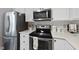 Modern kitchen with stainless steel appliances, white cabinets, and decorative backsplash at 4413 Sugarbend Way, Raleigh, NC 27606