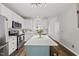 Spacious kitchen with white cabinets, stainless steel appliances, and an island with stools at 4413 Sugarbend Way, Raleigh, NC 27606