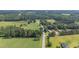 An aerial perspective of a countryside area showing properties nestled among trees and open fields at 445 Lee County Line Rd, Broadway, NC 27505