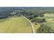 Aerial view of a home surrounded by green fields and lush trees, offering a serene and rural setting at 445 Lee County Line Rd, Broadway, NC 27505