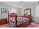 Cozy bedroom featuring a wooden four poster bed, dresser, and a retro hanging light fixture at 445 Lee County Line Rd, Broadway, NC 27505