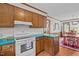 Charming kitchen with wood cabinets, white appliances, and cozy breakfast nook at 445 Lee County Line Rd, Broadway, NC 27505