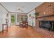Open-concept living room with brick fireplace, hardwood floors, and access to a deck at 445 Lee County Line Rd, Broadway, NC 27505