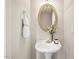 Charming powder room with pedestal sink, gold mirror, and decorative floral accents at 4619 Regency Dr, Durham, NC 27713