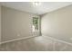 Neutral bedroom features a window providing natural light and carpeted floors at 4619 Regency Dr, Durham, NC 27713