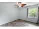 This bedroom offers hardwood floors, ceiling fan, and a double-hung window with lovely outside views at 4709 Tyne Dr, Durham, NC 27703