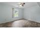 This bedroom features hardwood floors, ceiling fan, and double-hung window overlooking a fenced yard at 4709 Tyne Dr, Durham, NC 27703
