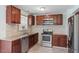 This kitchen features tile backsplash, ample cabinetry, stainless steel refrigerator, and granite countertops at 4709 Tyne Dr, Durham, NC 27703