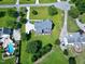 An aerial view shows a house with a gray roof, a patio, and a well-maintained lawn with mature trees at 5013 Wheatridge Dr, Fuquay Varina, NC 27526