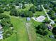 Aerial view of a community with houses and a horse-riding facility with green fields and trees at 5013 Wheatridge Dr, Fuquay Varina, NC 27526