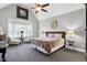 Bright bedroom with a bay window, two bedside tables with lamps and ceiling fan at 5013 Wheatridge Dr, Fuquay Varina, NC 27526