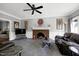 The living room features a brick fireplace, ceiling fan, and gray carpet at 5013 Wheatridge Dr, Fuquay Varina, NC 27526