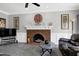 The living room boasts a brick fireplace, ceiling fan, and gray carpet at 5013 Wheatridge Dr, Fuquay Varina, NC 27526