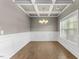Formal dining room with a coffered ceiling, wainscoting, and hardwood floors at 509 Holden Forest Dr, Youngsville, NC 27596