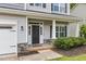 Covered front porch with stone accents, gray siding, and a black front door at 509 Holden Forest Dr, Youngsville, NC 27596