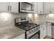 Close up view of a kitchen stove, granite countertops and gray backsplash at 509 Holden Forest Dr, Youngsville, NC 27596