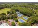 Aerial view of the community tennis courts, pool, and golf course, all surrounded by lush greenery at 5109 Windance Pl, Holly Springs, NC 27540