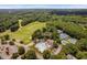 Aerial view featuring the pool, tennis courts, golf course, and parking, nestled within a lush landscape at 5109 Windance Pl, Holly Springs, NC 27540