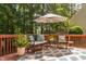 Inviting back deck with outdoor seating, an umbrella, and a view of lush trees at 5109 Windance Pl, Holly Springs, NC 27540