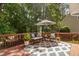 Inviting back deck with outdoor seating, an umbrella, and a view of lush trees at 5109 Windance Pl, Holly Springs, NC 27540