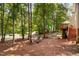 Backyard area with mature trees and a charming seating area at 5109 Windance Pl, Holly Springs, NC 27540