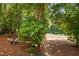Spacious backyard area with mature trees and a charming seating area at 5109 Windance Pl, Holly Springs, NC 27540