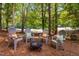 Backyard lounge featuring four chairs and a fire pit, surrounded by lush trees at 5109 Windance Pl, Holly Springs, NC 27540
