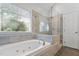 Bright bathroom featuring soaking tub and a walk-in glass shower at 5109 Windance Pl, Holly Springs, NC 27540