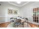 Charming dining room with hardwood floors, wainscoting, and a round wood table set for four at 5109 Windance Pl, Holly Springs, NC 27540