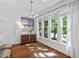 Dining area featuring hardwood floors, a modern chandelier, and large windows with backyard views at 5109 Windance Pl, Holly Springs, NC 27540