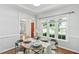 Elegant dining area with hardwood floors, wainscoting, and a round wooden table set for four at 5109 Windance Pl, Holly Springs, NC 27540