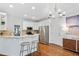 Well-lit kitchen featuring a breakfast bar, stainless steel appliances, and white cabinetry at 5109 Windance Pl, Holly Springs, NC 27540