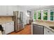 Kitchen area with stainless steel refrigerator and dishwasher and lots of natural light at 5109 Windance Pl, Holly Springs, NC 27540