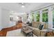 Bright living room featuring hardwood floors, large windows, and a comfortable seating area at 5109 Windance Pl, Holly Springs, NC 27540