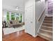 Cozy living room featuring hardwood floors, large windows, and comfortable seating near the staircase at 5109 Windance Pl, Holly Springs, NC 27540
