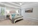 Spacious primary bedroom featuring a tray ceiling, neutral colors, and large windows at 5109 Windance Pl, Holly Springs, NC 27540