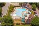 Aerial view of a community pool with lounge chairs, umbrellas, and a well-maintained pool house at 5109 Windance Pl, Holly Springs, NC 27540