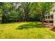 Large backyard with play set and swing set surrounded by mature trees at 5205 Coffeetree Dr, Raleigh, NC 27613