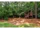 Backyard features a playhouse and swing set on a well maintained lawn at 5205 Coffeetree Dr, Raleigh, NC 27613