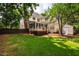 Expansive backyard with lush lawn, mature trees, deck, screened porch, and fence at 5205 Coffeetree Dr, Raleigh, NC 27613